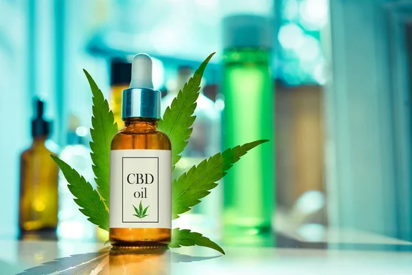 CBD OIL glass bottle, tincture and hemp leaf on a background of a medical laboratory. Concept of legal medicine — Stock Photo, Image
