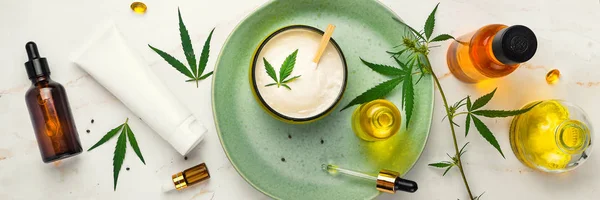 Bank av medicinsk grädde med CBD olja, flaska cannabis olja, kapslar, på en grön tallrik. Flat Lay, uppifrån. Banner — Stockfoto