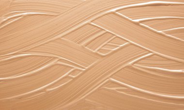 Sıvı temelin dokusu. Yüz sıvısı temel dokusunu kapat. Sıvı temelden yapılmış bir arka plan. Bej sıvısı gizleyici leke, makyaj arkaplanı