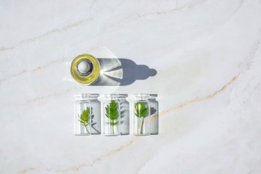 Beyaz arka planda doğal yağlar ve organik kozmetikler için bitkilerle dolu şişeler. Doğal ürünlerin, takviyelerin, kozmetiklerin üretimi için bir eko laboratuvarı kavramı