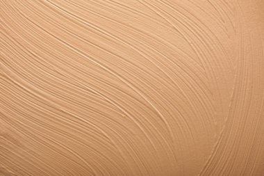 Sıvı temelin dokusu. Yüz sıvısı temel dokusunu kapat. Sıvı temelden yapılmış bir arka plan. Bej sıvısı gizleyici leke, makyaj arkaplanı