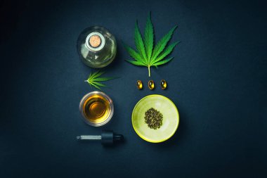 Esrar yapraklı, siyah modaya uygun arka planda tıbbi CBD yağı. Tıbbi marihuana tentürü konsepti. Moda Düz Minimalizmi