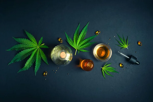 Óleo de CBD, tintura com folhas de cânhamo sobre fundo preto Conceito de cannabis medicinal — Fotografia de Stock