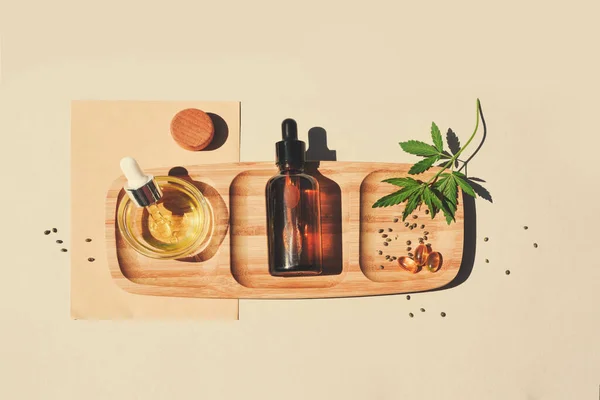 Olej z CBD, nalewka z liśćmi marihuany na beżowym tle. Nasiona konopi — Zdjęcie stockowe