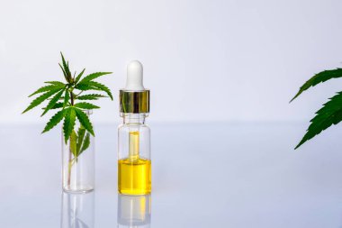 Beyaz bir laboratuvar masasında eczacılık CBD yağı ve kenevir tütünü.