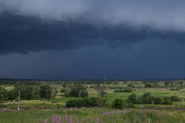 Tepenin tepesinden yaklaşan sağanak yağış ve Rusya 'nın Moskova bölgesinde demiryolu manzarası.