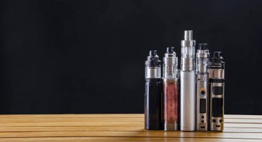 Popüler vaping e cig aygıtları mod.electronic sigara ahşap arka plan üzerinde. Buharlaştırıcı e-cig eski aygıt modeli. 