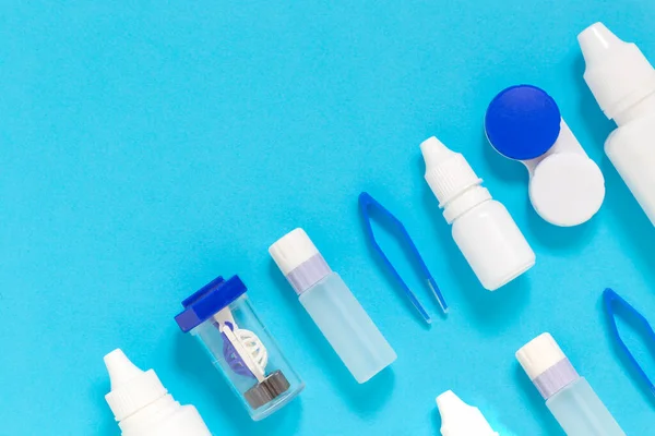 Renkli düz görüş düzeltme lensleri mavi arkaplanda kopya alanı olan ekipmanları düzeltir: göz damlası, kaplar, lensler, twizzlers, sıvılar