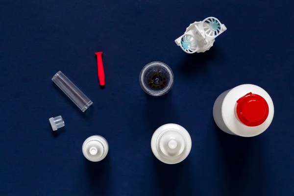 Göz damlası, konteynırlar, lensler, camlar, sıvılar mavi zemin üzerindeki renk düzleştirici lensler