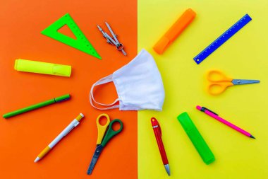 Cetvel olarak öğrenci aksesuarları, kalem açacağı, tıbbi yüz maskesi etrafında makas. Okul sezonu başlıyor ve güvenli bir şekilde okul konseptine geri dönüyoruz.