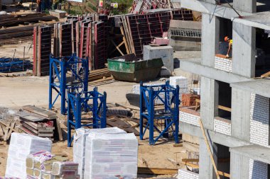 Şehrin ortasında gürültülü bir inşaat alanı. Yeni apartmanlar inşa etmek için. Etkin kentsel gelişim ve yaz yapıları