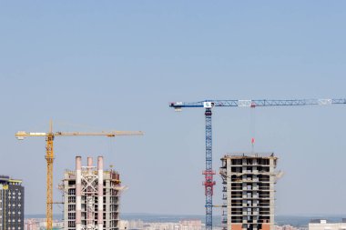 İnşaat vinçleri yeni modern gökdelenler inşa ediyor. Yüksek binalarla etkin kentsel gelişim