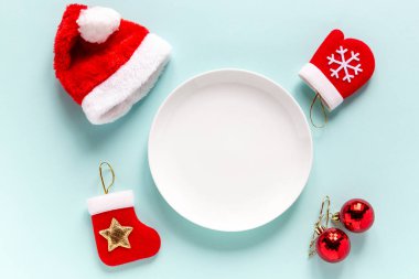 Noel süsleri, Noel Baba şapkası ve ortasındaki boşluğu kopyalayan boş bir tabak. Yeni yıl ve Noel festivali menü hazırlama konsepti