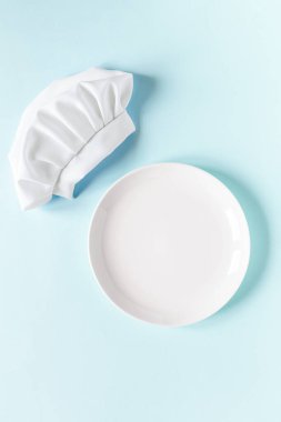 Üzerinde metin ve şef şapkası olan beyaz boş tabak. Yemek menüsü hazırlama
