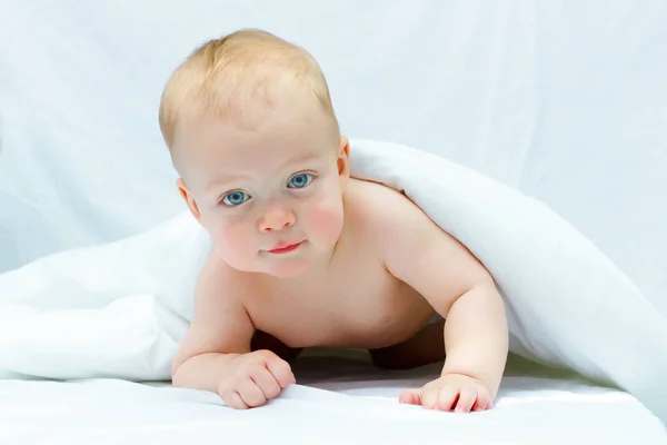 Hermoso niño sonriente después del baño. Lindo niño en la cama debajo de la manta —  Fotos de Stock