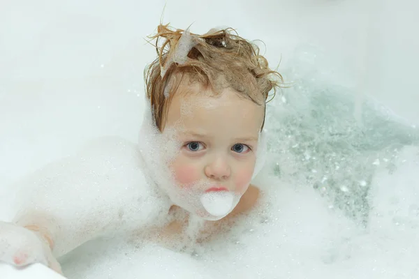 Zbliżenie twarzy urocza toddler chłopiec kąpieli w wannie, zadowolony ładny mały chłopiec gry w łazience, pojęcie opieki zdrowia dzieci z dużą ilością piany — Zdjęcie stockowe