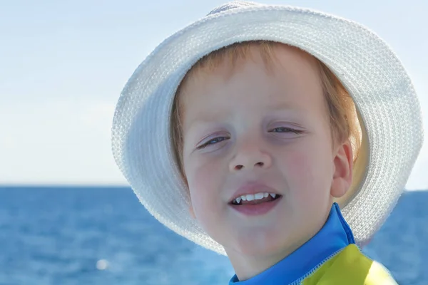 Portret van Kaukasische happy baby boy in de hoed. Kind lacht in zomerdag op het strand. Kid is genieten van de Oceaan. Afbeelding heeft copyspace voor tekst. Outdoor, close-up. — Stockfoto