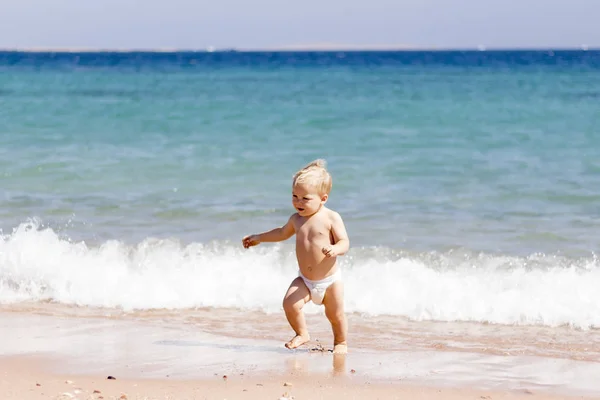 Dziecko w pieluchach i kapelusz na plaży - radość lato — Zdjęcie stockowe