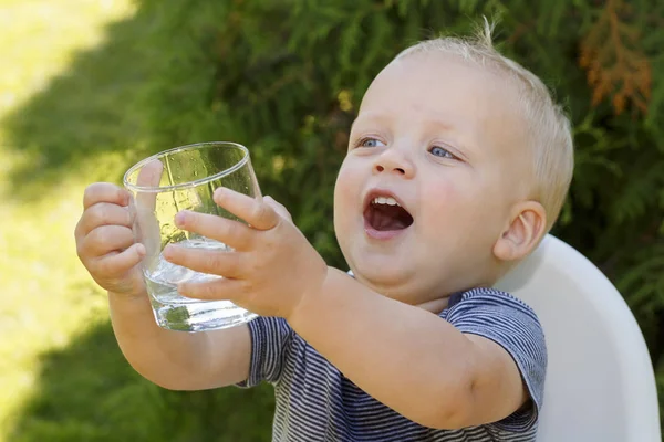 Портрет мальчика, пьющего стакан воды. Фотография на открытом воздухе — стоковое фото