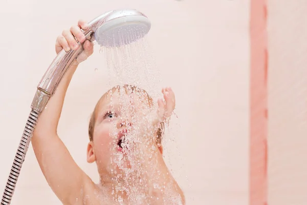 Ładny chłopczyk bierze prysznic w łazience — Zdjęcie stockowe