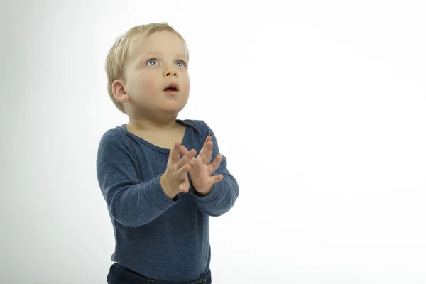 Adorable little boy against white background, looking up, studio shot, praying pose. Copy space — Stock Photo, Image