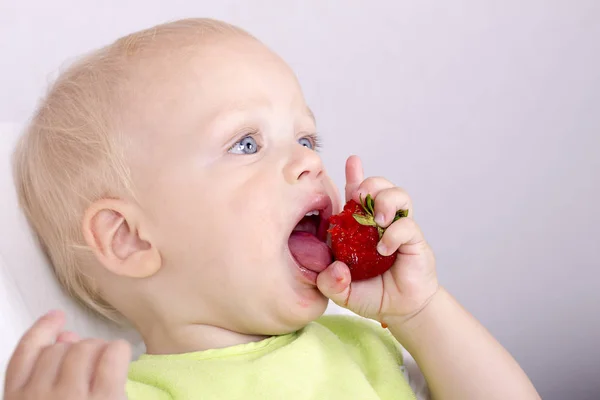 Счастливый маленький мальчик с клубникой, милый малыш ест спелые фрукты — стоковое фото