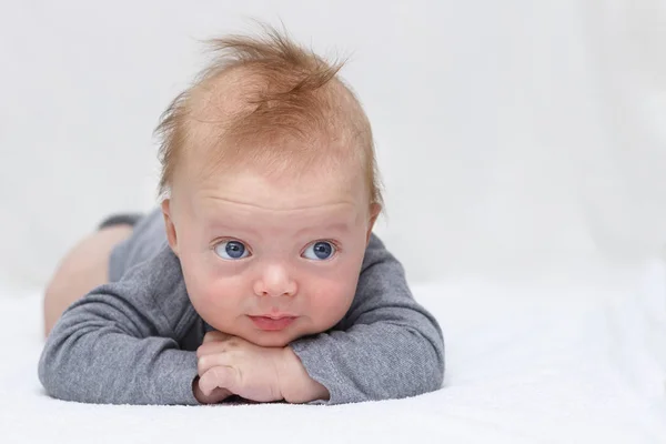 Smiling happy infant baby boy laying on the tummy and looking at camera copy space — Stock Photo, Image