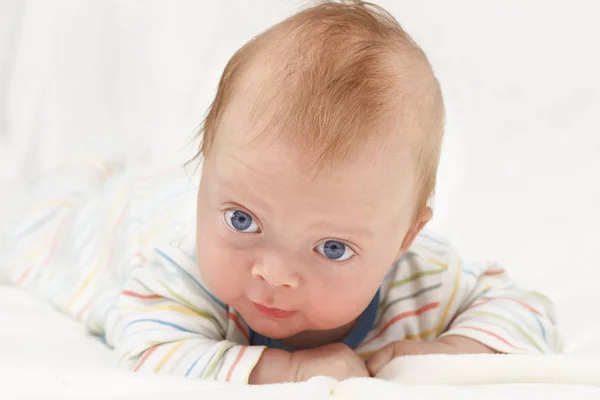 Leende Happy Infant Baby Boy om på magen och titta på kamera kopia utrymme — Stockfoto