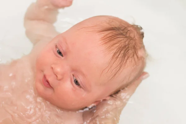 Cara cercana de linda y saludable sonrisa de niño bebé durante la hora del baño . —  Fotos de Stock