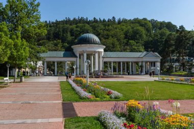 Marianske Lazne / Çek Cumhuriyeti - 11 Ağustos 2020: Rudolph ve Caroline bahar sütunlarının önü yeşil çimlerle ve renkli çiçeklerle dolu. Ünlü bir kaplıca şehrinde güneşli bir yaz günü.