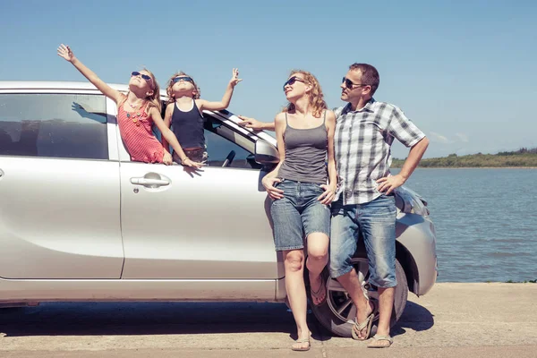 Happy people standing near car. They having fun on the nature.  Concept of friendly family and of summer vacation.