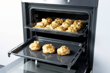 Ev yapımı profiterol fırında. Pişirme çerezler, Fransız tatlı, pasta ve şekerlemeler arka plan işlemi.