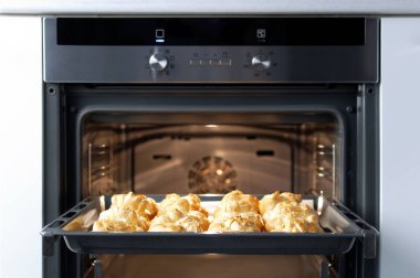 Ev yapımı profiterol fırında. Pişirme çerezler, Fransız tatlı, pasta ve şekerlemeler arka plan işlemi.