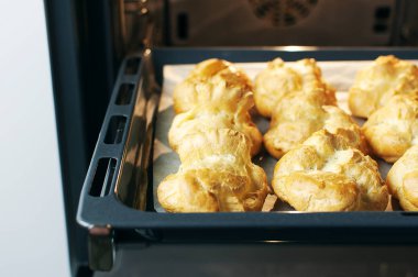 Ev yapımı profiterol fırında. Pişirme çerezler, Fransız tatlı, pasta ve şekerlemeler arka plan işlemi.