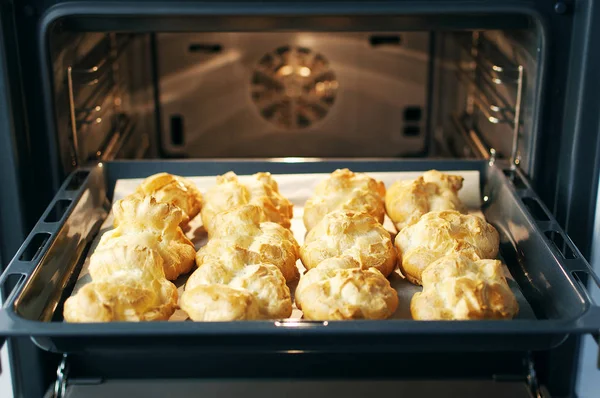 Ev yapımı profiterol fırında. Pişirme çerezler, Fransız tatlı, pasta ve şekerlemeler arka plan işlemi.