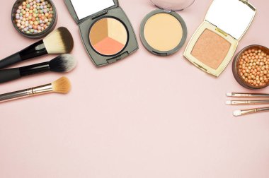 Pembe bir arka plan üzerinde renkli kozmetik toz allık düzeltici Fırçalar ayarlayın. Makyaj Aksesuarları üst görünümü