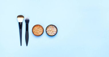 Dekoratif kozmetik kümesi makyaj toz allık düzeltici fırçalar üzerinde mavi arka plan için. Makyaj Aksesuarları üst görünümü