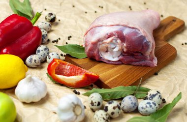 Ham Türkiye uyluk sarımsak limon elma kırmızı dolmalık biber Bıldırcın yumurta baharatlar ahşap bir gemide. Üstten görünüm bir Türkiye, bej Kağıt arka plan üzerinde bıçak. Mutfak arka plan