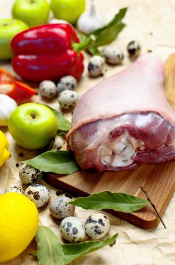 Ham Türkiye uyluk sarımsak limon elma kırmızı dolmalık biber Bıldırcın yumurta baharatlar ahşap bir gemide. Üstten görünüm bir Türkiye, bej Kağıt arka plan üzerinde bıçak. Mutfak arka plan