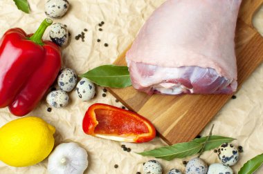 Ham Türkiye uyluk sarımsak limon elma kırmızı dolmalık biber Bıldırcın yumurta baharatlar ahşap bir gemide. Üstten görünüm bir Türkiye, bej Kağıt arka plan üzerinde bıçak. Mutfak arka plan