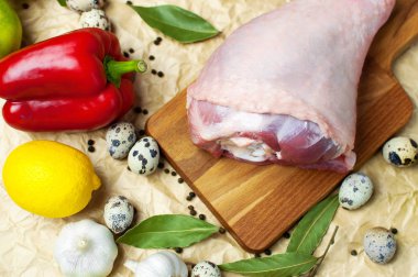 Ham Türkiye uyluk sarımsak limon elma kırmızı dolmalık biber Bıldırcın yumurta baharatlar ahşap bir gemide. Üstten görünüm bir Türkiye, bej Kağıt arka plan üzerinde bıçak. Mutfak arka plan