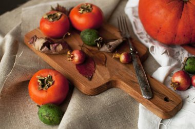 Sonbahar düzenleme: Trabzon hurması, kabak, feijoa sonbahar yaprakları ile. Sonbahar fudfoto yaşam tarzı