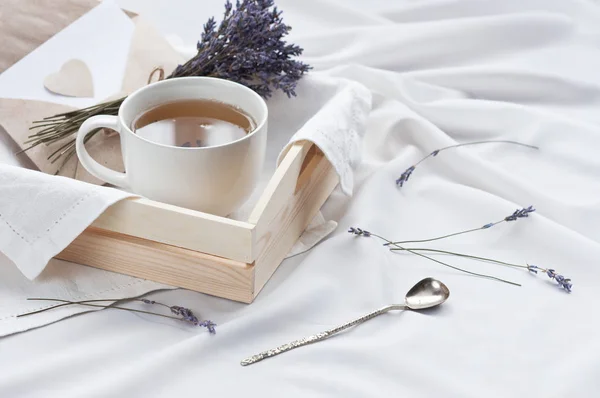 熱いお茶とベッド ラベンダー ラブレターのカップとトレイ ハーブティー ホット飲む気分愛のメッセージ朝食ベッド朝のライフ スタイル — ストック写真