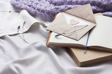 Not defteri mektup ve yatakta beyaz Tekstil ekose ve lavanta ile kitap. Günlük zarf yaşam tarzı şal eşarp lavanta rahat arka plan