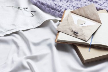 Not defteri mektup ve yatakta beyaz Tekstil ekose ve lavanta ile kitap. Günlük zarf yaşam tarzı şal eşarp lavanta rahat arka plan