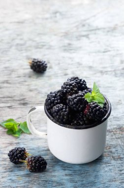 Nane ile taze böğürtlen kopya alanı bir rustik ahşap zemin üzerine beyaz bir kaba bırakır. Berry, vitaminler, gıda arka plan