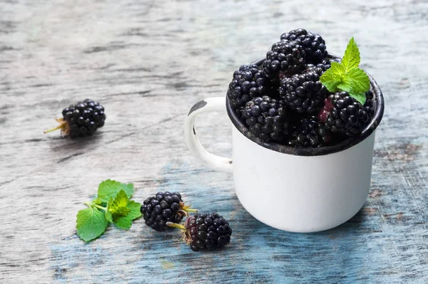 Nane ile taze böğürtlen kopya alanı bir rustik ahşap zemin üzerine beyaz bir kaba bırakır. Berry, vitaminler, gıda arka plan