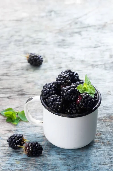 Nane ile taze böğürtlen kopya alanı bir rustik ahşap zemin üzerine beyaz bir kaba bırakır. Berry, vitaminler, gıda arka plan