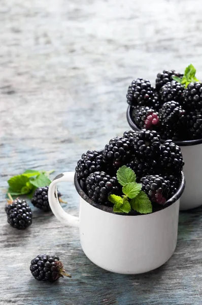 Nane ile taze böğürtlen kopya alanı bir rustik ahşap zemin üzerine beyaz bir kaba bırakır. Berry, vitaminler, gıda arka plan