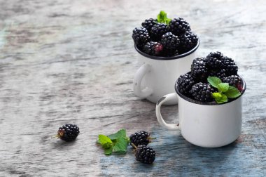 Nane ile taze böğürtlen kopya alanı bir rustik ahşap zemin üzerine beyaz bir kaba bırakır. Berry, vitaminler, gıda arka plan